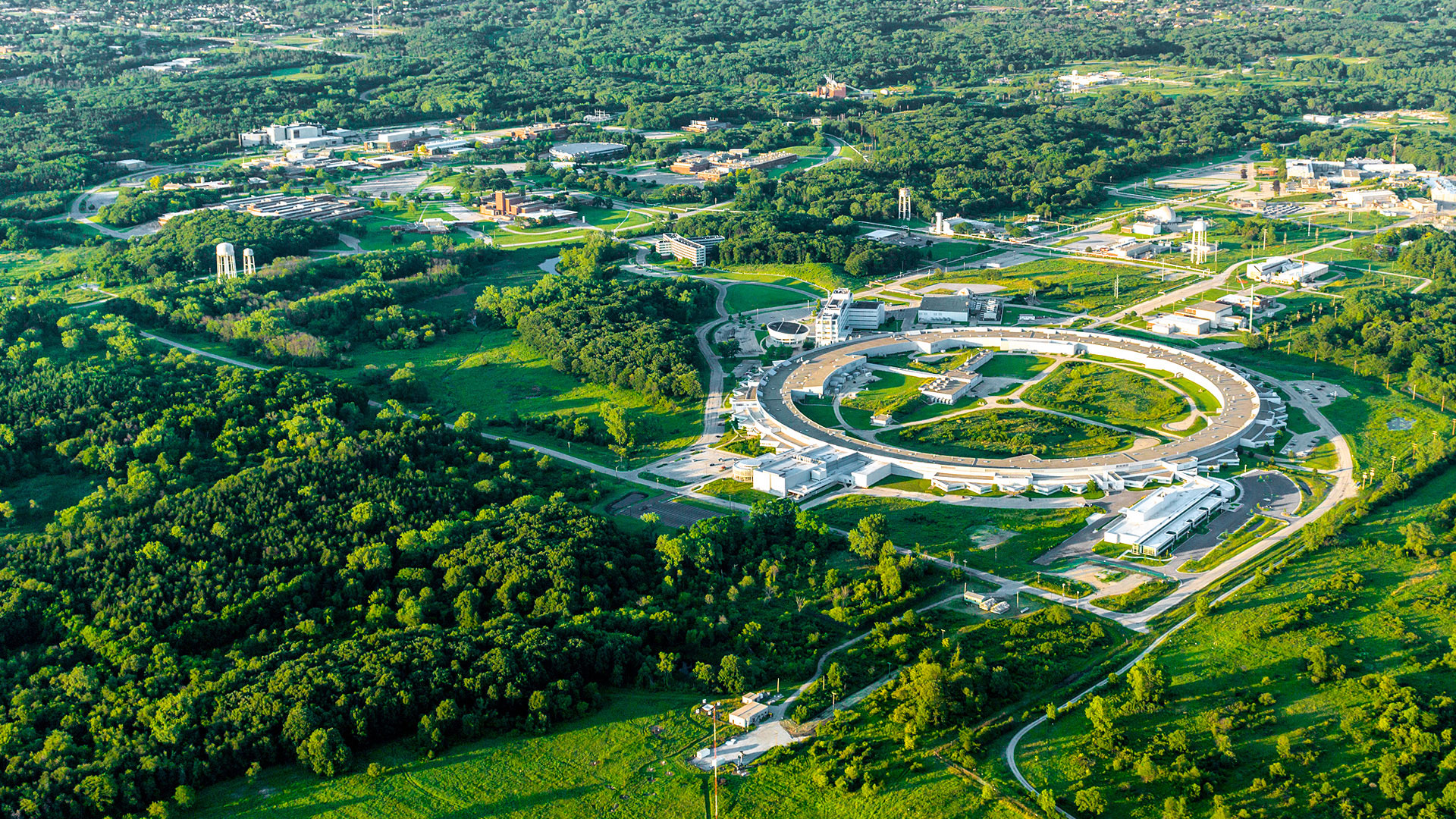 Aerial view of Argonne and CNM surrounded by green landscape.