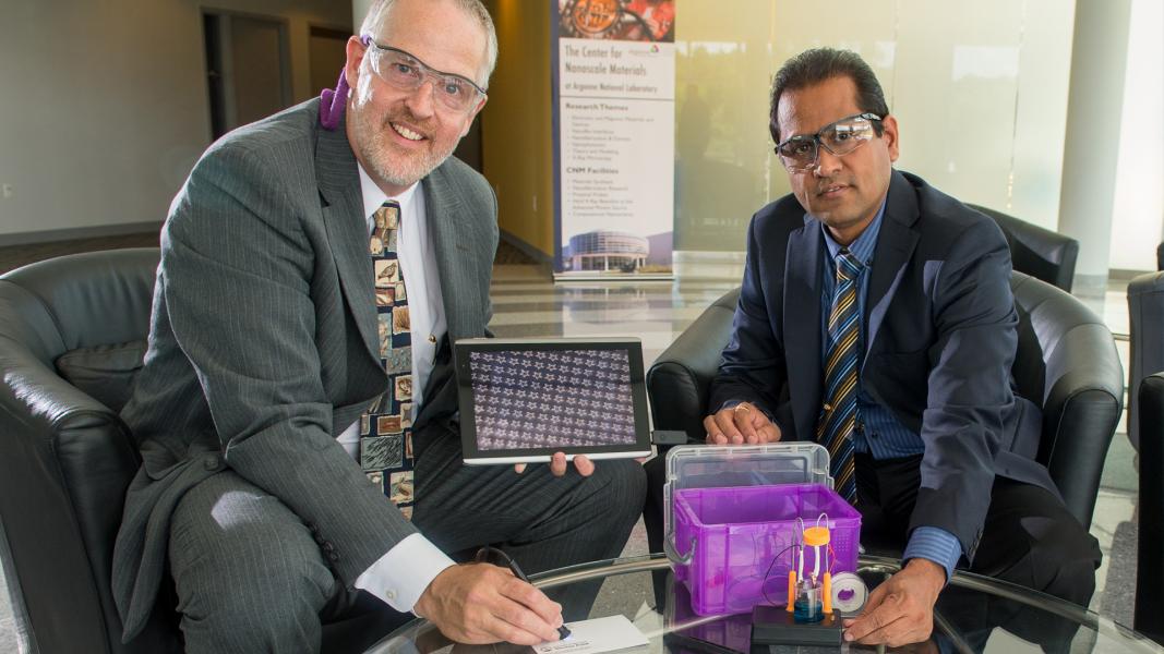 Two goggled men in suits displaying purple box.