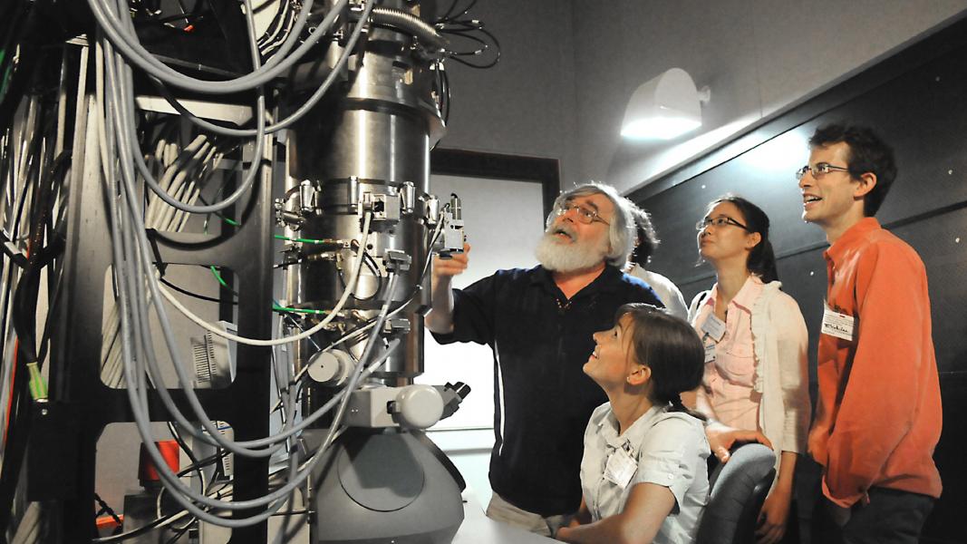 Five people admiring large piece of scientific equipment.